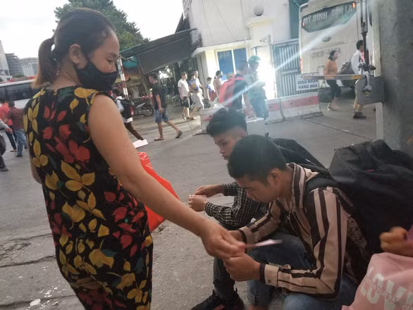 Phát tờ rơi tìm người làm - Ảnh: V.TUẤN