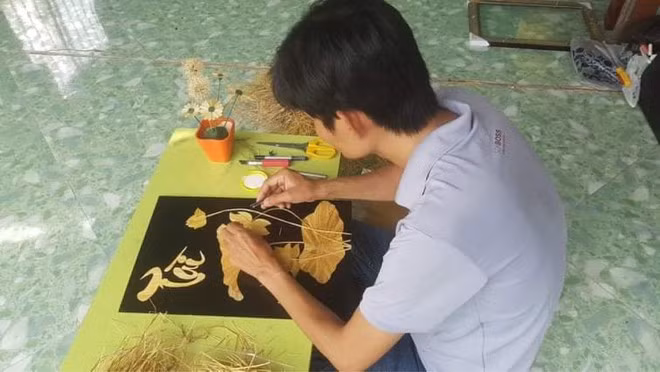 Thầy Linh xử lý rơm, tạo hình và dán ép rơm vào giấy- ẢNH: DUY TÂN