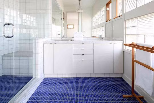 Một sàn lát gạch khảm nhỏ với tông màu xanh lam, vài điểm nhấn bằng nội thất gỗ tạo giúp không gian sang trọng.