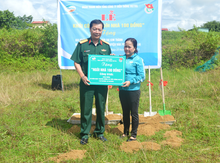 Giám đốc Viettel Gia Lai trao tặng bảng tựng trưng ngôi nhà 100 đồng cho chị Kim Thành. Ảnh: Anh Huy