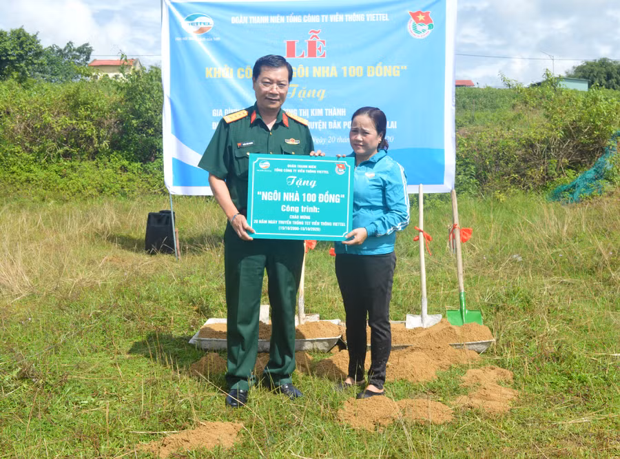 Giám đốc Viettel Gia Lai trao tặng bảng tựng trưng ngôi nhà 100 đồng cho chị Kim Thành. Ảnh: Anh Huy