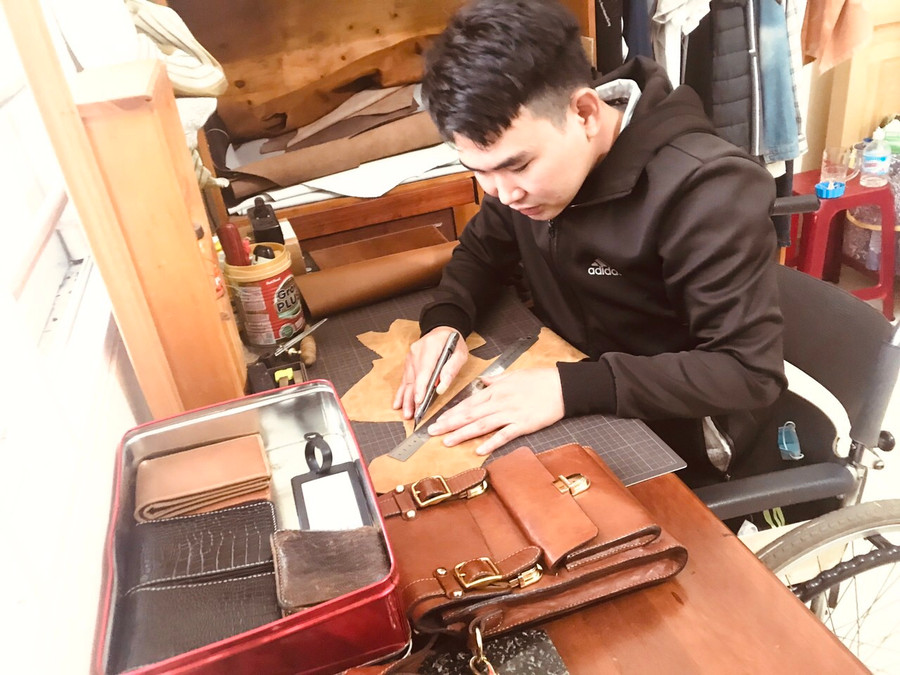 Anh Nguyễn Văn Thành làm các vật dụng túi xách, ví, thắt lưng để có thu nhập trang trải cuộc sống. Ảnh: Thủy Bình