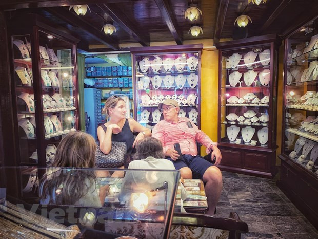 Khách quốc tế tại một gian hàng trong phố cổ Hội An thời điểm chưa có dịch COVID-19. (Ảnh: Mai Mai/Vietnam+)