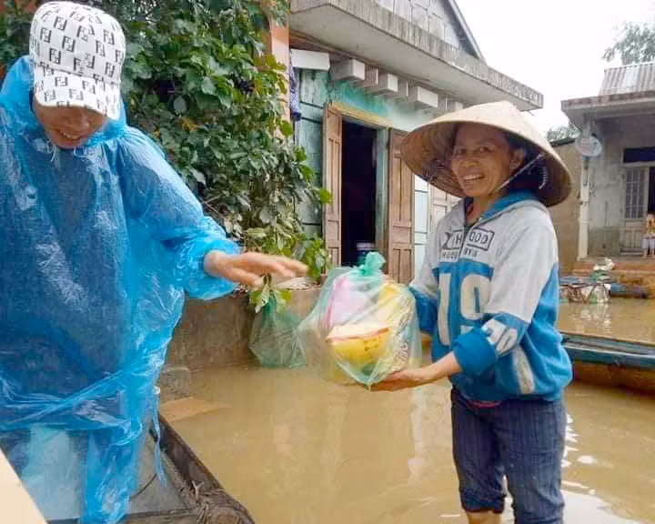 Người dân vùng lũ huyện Hải Lăng (tỉnh Quảng Trị) phấn khởi khi nhận được hàng cứu trợ (ảnh nhân vật cung cấp).