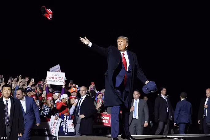 Tổng thống Trump ném mũ cho người ủng hộ tại cuộc vận động tranh cử ở sân bay quốc tế Duluth. Ông không đeo khẩu trang. Ảnh: AP Tổng thống Trump ném mũ cho người ủng hộ tại cuộc vận động tranh cử ở sân bay quốc tế Duluth. Ông không đeo khẩu trang. Ảnh: AP
