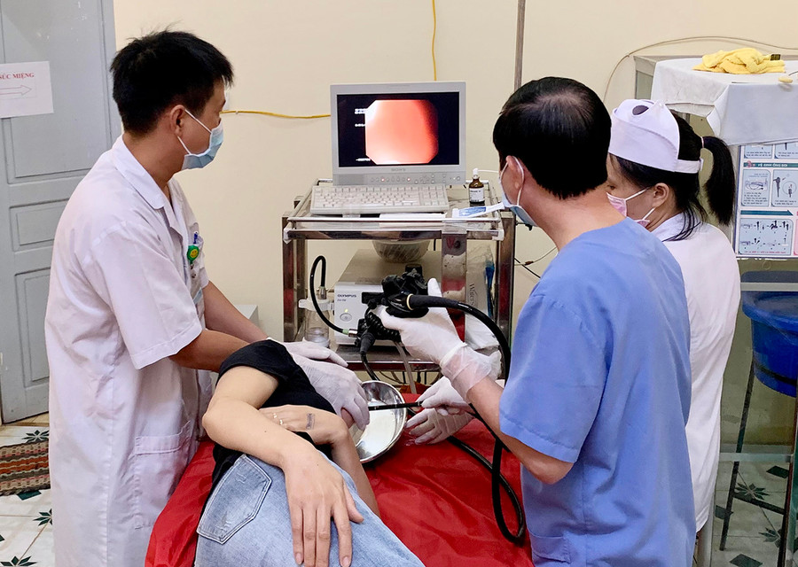  Phó Giáo sư- Tiến sĩ Nguyễn Duy Thắng (áo xanh) nội soi dạ dày cho một bệnh nhân. Ảnh: Như Nguyện