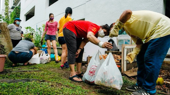 Người dân mang các túi thức ăn thừa tới một khu vườn cộng đồng để dùng làm phân trộn - Ảnh: SCMP
