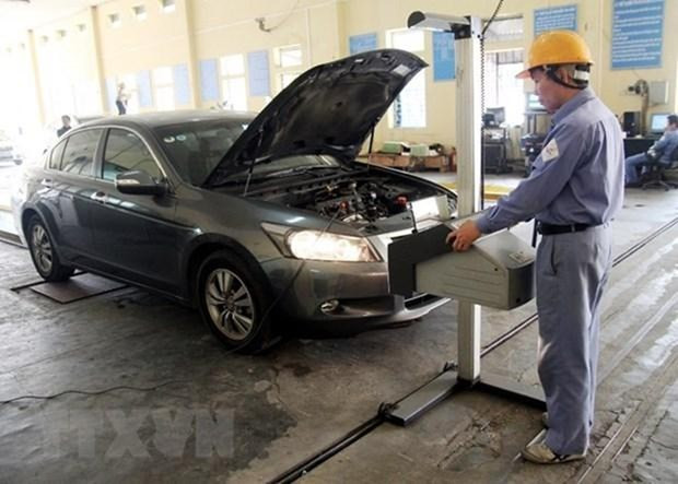 Đăng kiểm viên tiến hành kiểm định phương tiện đến đăng kiểm. (Ảnh: Hoàng Hùng/TTXVN)