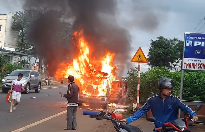 Người dân dùng bình cứu hỏa mini đến dập lửa giúp tài xế, nhưng ngọn lửa đã nhanh chóng bao trùm chiếc xe ẢNH: TRÙNG DƯƠNG