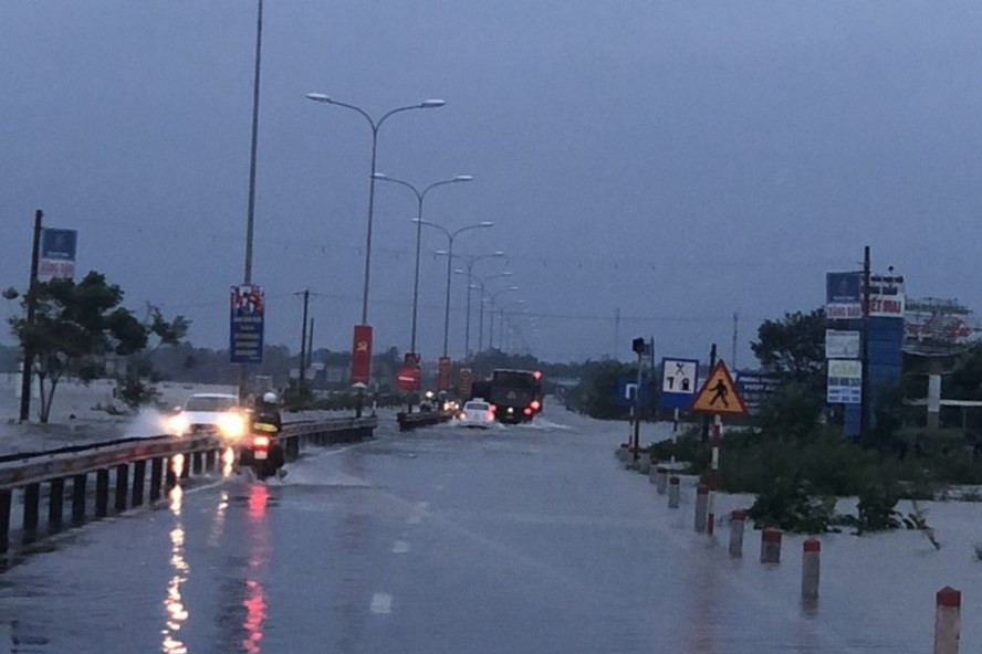 Quốc lộ 1 bị ngập khiến nhiều phương tiện lưu thông khó khăn. Ảnh: Công an