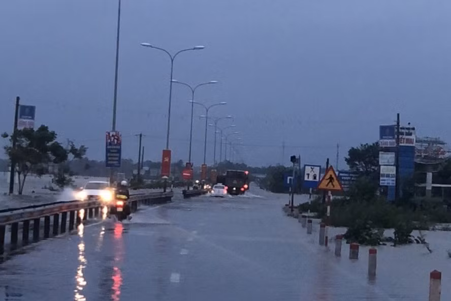 Quốc lộ 1 bị ngập khiến nhiều phương tiện lưu thông khó khăn. Ảnh: Công an