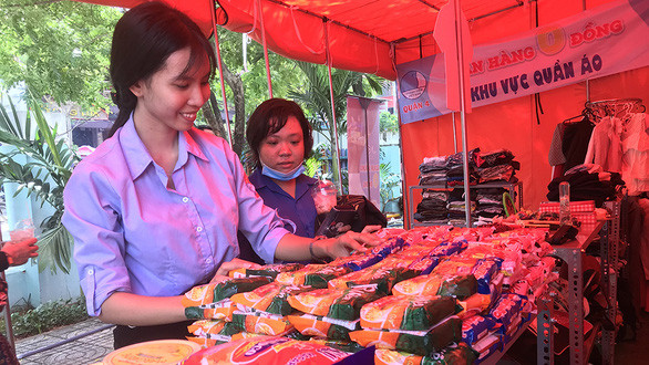 Các bạn trẻ chăm chút cho gian hàng 0 đồng của Hội LHTNVN Q.4 nhằm hỗ trợ những người lao động khó khăn - Ảnh: K.ANH