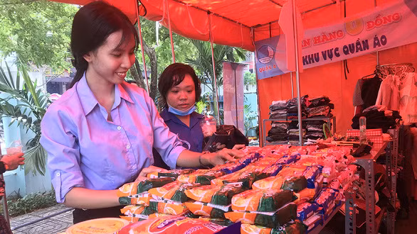 Các bạn trẻ chăm chút cho gian hàng 0 đồng của Hội LHTNVN Q.4 nhằm hỗ trợ những người lao động khó khăn - Ảnh: K.ANH