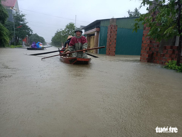 Một người đàn ông ở xã Cẩm Vịnh, huyện Cẩm Xuyên, Hà Tĩnh vớt vát tài sản chìm trong lũ - Ảnh: VĂN ĐỊNH