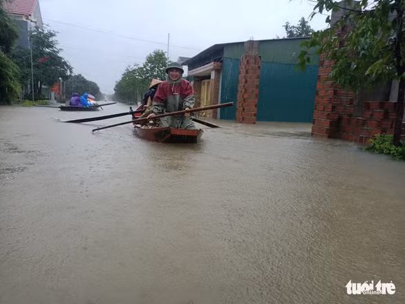 Một người đàn ông ở xã Cẩm Vịnh, huyện Cẩm Xuyên, Hà Tĩnh vớt vát tài sản chìm trong lũ - Ảnh: VĂN ĐỊNH