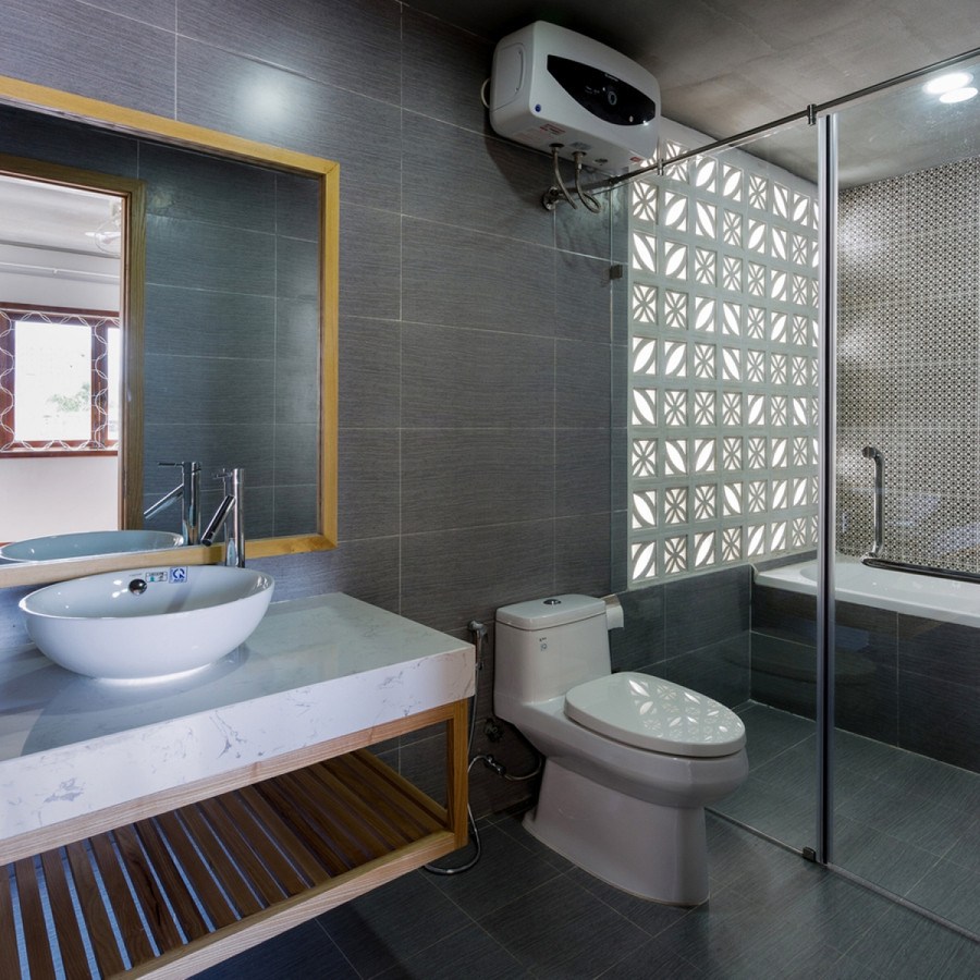 Phòng vệ sinh liền kề với phòng ngủ nằm phía sau nhà, thông ra giếng trời phía sau. Bức tường gạch hoa bê tông làm cho không gian vừa thông thoáng, vừa kín đáo. Phòng vệ sinh liền kề với phòng ngủ nằm phía sau nhà, thông ra giếng trời phía sau. Bức tường gạch hoa bê tông làm cho không gian vừa thông thoáng, vừa kín đáo.