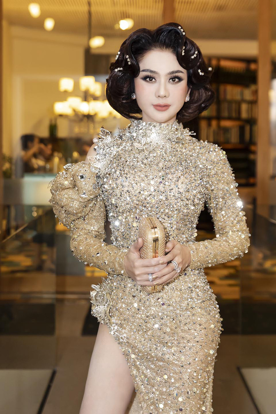 Riêng Lâm Khánh Chi thu hút sự chú ý khi tham gia một sự kiện trong tuần với bộ váy lấp lánh được thiết kế ôm sát đường cong. Điểm nhấn của bộ trang phục này là đường xẻ tà cao hút mắt giúp người đẹp khoe khéo đôi chân dài quyến rũ.