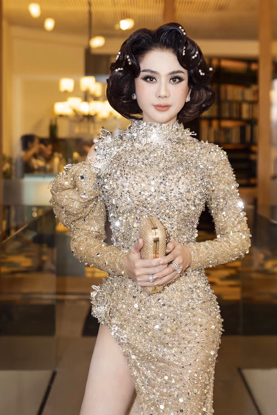 Riêng Lâm Khánh Chi thu hút sự chú ý khi tham gia một sự kiện trong tuần với bộ váy lấp lánh được thiết kế ôm sát đường cong. Điểm nhấn của bộ trang phục này là đường xẻ tà cao hút mắt giúp người đẹp khoe khéo đôi chân dài quyến rũ.