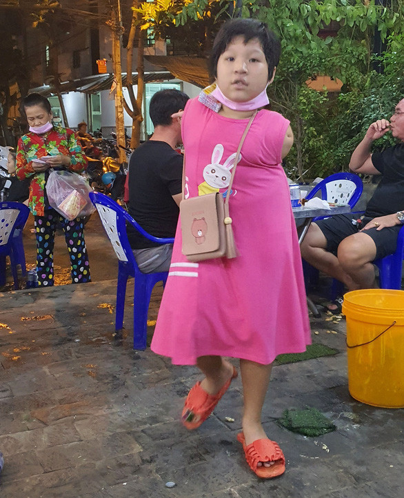 Bé Ân kẹp vé số đi bán - Ảnh: DIỆU QUÍ