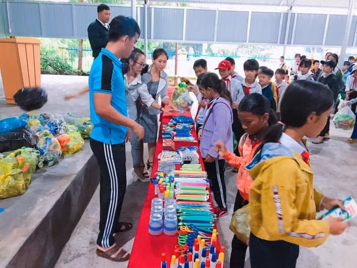Các em học sinh háo hức đổi rác thải nhựa lấy đồ dùng học tập. Ảnh: Vũ Chi