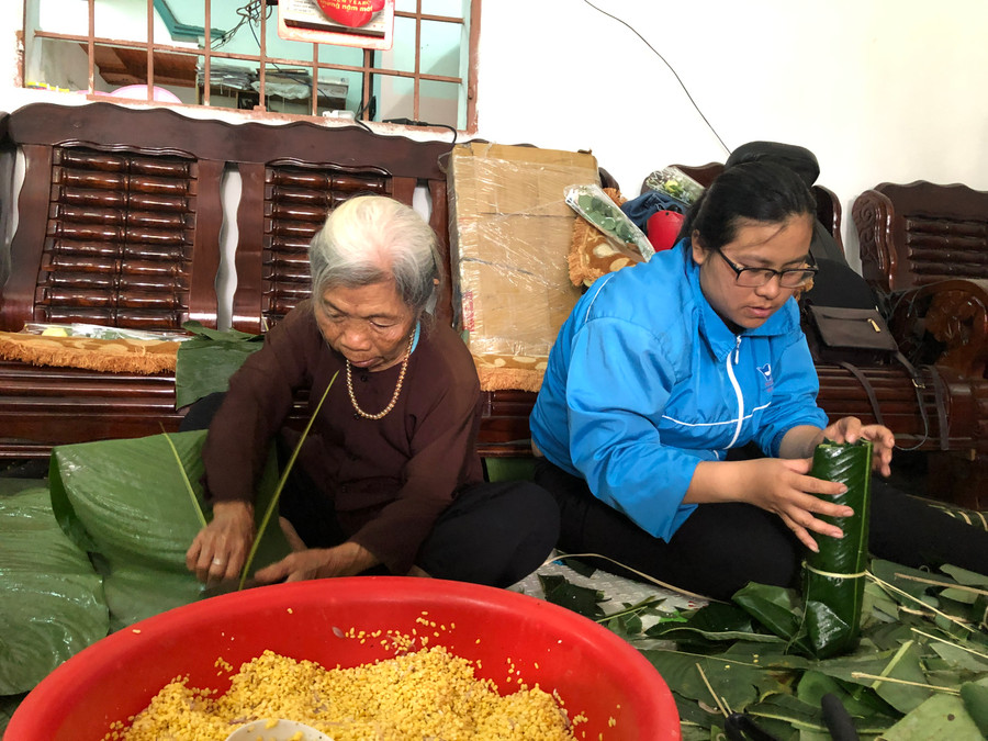 Bà Lê Thị Hà (bìa trái; tổ 2, thị trấn Kon Dơng, huyện Mang Yang) tham gia gói bánh. Ảnh: Nguyễn Giang