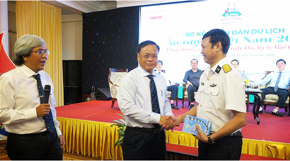 Chủ tịch UBND huyện Hoàng Sa Võ Ngọc Đồng (giữa) tặng sách cho Đại tá Lê Nam Sơn, Phó Lữ đoàn trưởng, Lữ đoàn 125, Bộ tư lệnh Vùng 2 Hải quân (phải) - Ảnh: T.T.D