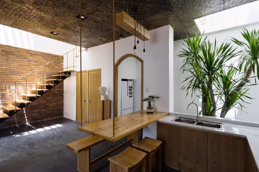 Góc bếp và phòng ăn mở ra phía cầu thang và giếng trời phía sau nhà. Bàn ăn được bố trí liền với kệ bếp để tiết kiệm diện tích. Góc bếp và phòng ăn mở ra phía cầu thang và giếng trời phía sau nhà. Bàn ăn được bố trí liền với kệ bếp để tiết kiệm diện tích.