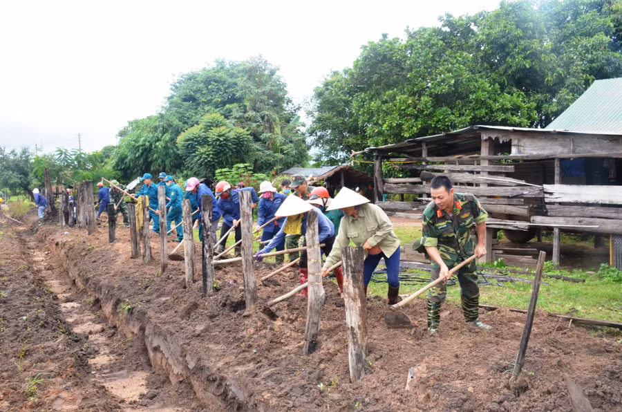  Cán bộ, chiến sĩ Trung đoàn Kinh tế- Quốc phòng giúp nhân dân làm hàng rào. Ảnh: Vĩnh Hoàng