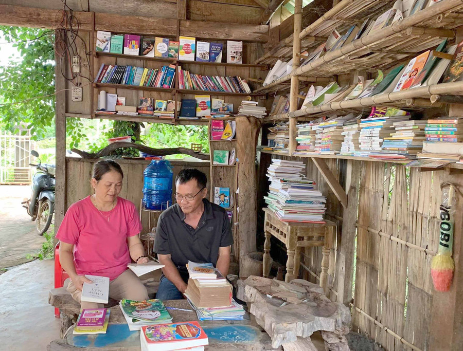 Vợ chồng chị Nguyễn Thị Minh sắp xếp phân loại các đầu sách tại thư viện. Ảnh: Hồng Thương