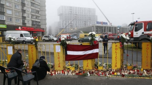  Người dân Latvia thắp nến và đặt hoa tưởng niệm những người xấu số ở phía trước siêu thị bị sập mái.