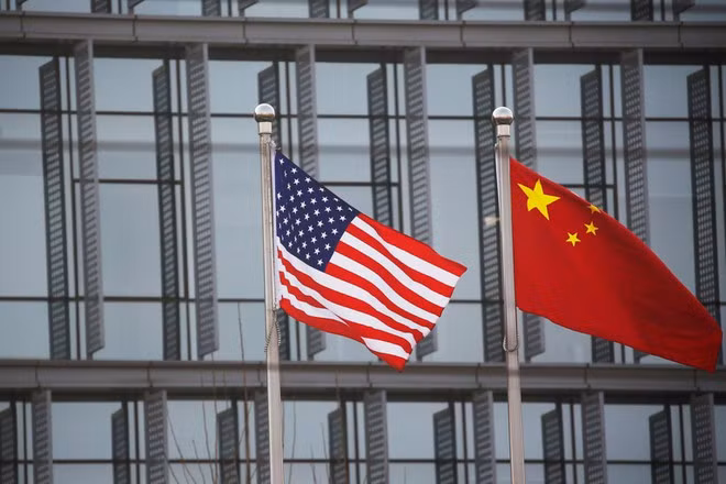 Quốc kỳ Mỹ và Trung Quốc bên ngoài một công ty Mỹ ở Bắc Kinh. Ảnh: REUTERS