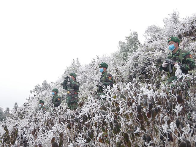 Các cán bộ, chiến sĩ Đồn biên phòng Xín Cái tuần tra trong băng giá. ẢNH: HÀ LINH