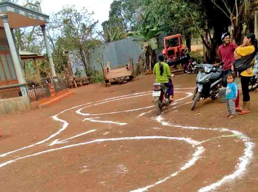 Vẽ sa hình tại sân nhà một hộ dân ở huyện Chư Sê để bà con có thể tự tập luyện để sát hạch cấp giấy phép lái xe hạng A1. Ảnh: Lê Hòa