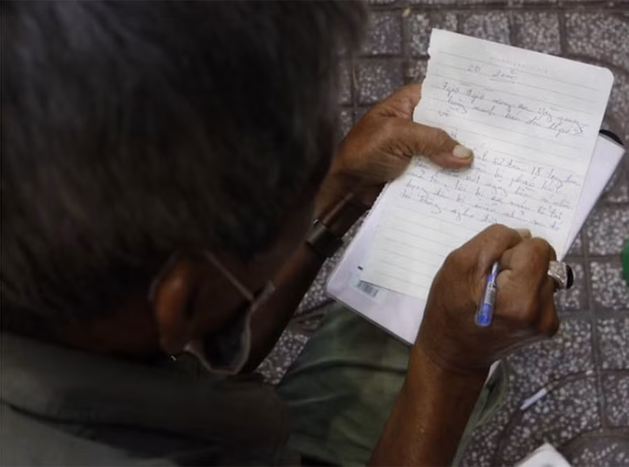 Ông nắn nót viết từng chữ đáp lại khi được hỏi