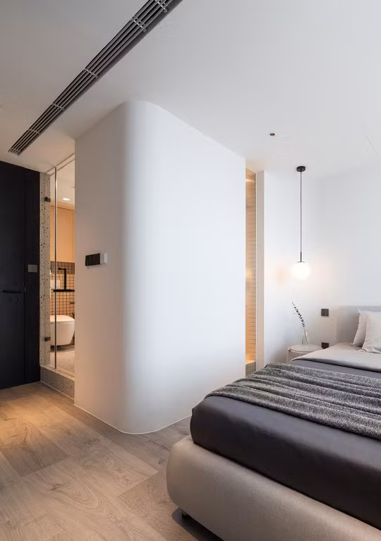 Tường ngăn khu vệ sinh với phòng ngủ được lắp một tấm kính để lấy sáng từ bên ngoài. Bức tường được bo tròn để khi đi vào, người ở không bị chạm phải cảm giác góc cạnh.