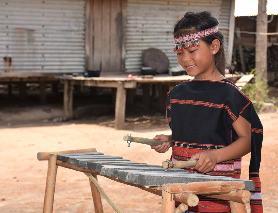 Em Đinh Thị Thai say mê với những thanh âm trầm bổng của đàn đá. Ảnh: Trần Dung