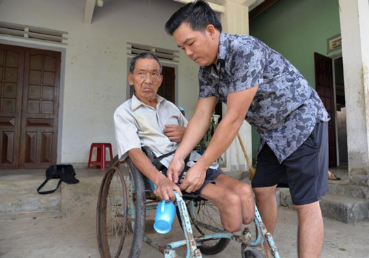 Ông Phạm Đình Vàng bị mất đôi chân do bom mìn. Ảnh: TỬ TRỰC