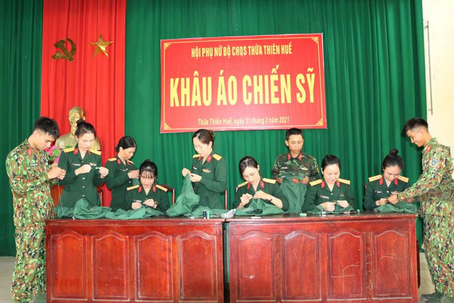 Hướng dẫn các chiến sĩ trẻ cách khâu áo. Ảnh: TRẦN TÌNH