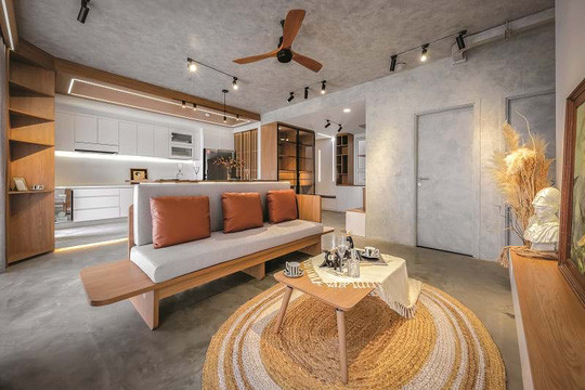 Những gam màu được sử dụng cho căn hộ phần lớn là tông lạnh. Chủ nhà là người rất có gu riêng và tính cách trầm ổn, việc sử dụng hiệu ứng bêtông cho sàn, tường và trần chính là phương án lý tưởng nhất để làm nổi bật lên cá tính này. Điểm xuyết cho không gian là màu nâu gỗ cùng với ánh sáng tự nhiên từ những ô cửa lớn sát trần, tất cả kết hợp tạo nên tổng thể hài hòa và sang trọng. Chiếc quạt trần ngay bên trên chính là một điểm nhấn mang tính chất hoài cổ.