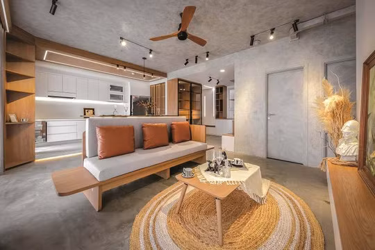 Những gam màu được sử dụng cho căn hộ phần lớn là tông lạnh. Chủ nhà là người rất có gu riêng và tính cách trầm ổn, việc sử dụng hiệu ứng bêtông cho sàn, tường và trần chính là phương án lý tưởng nhất để làm nổi bật lên cá tính này. Điểm xuyết cho không gian là màu nâu gỗ cùng với ánh sáng tự nhiên từ những ô cửa lớn sát trần, tất cả kết hợp tạo nên tổng thể hài hòa và sang trọng. Chiếc quạt trần ngay bên trên chính là một điểm nhấn mang tính chất hoài cổ.