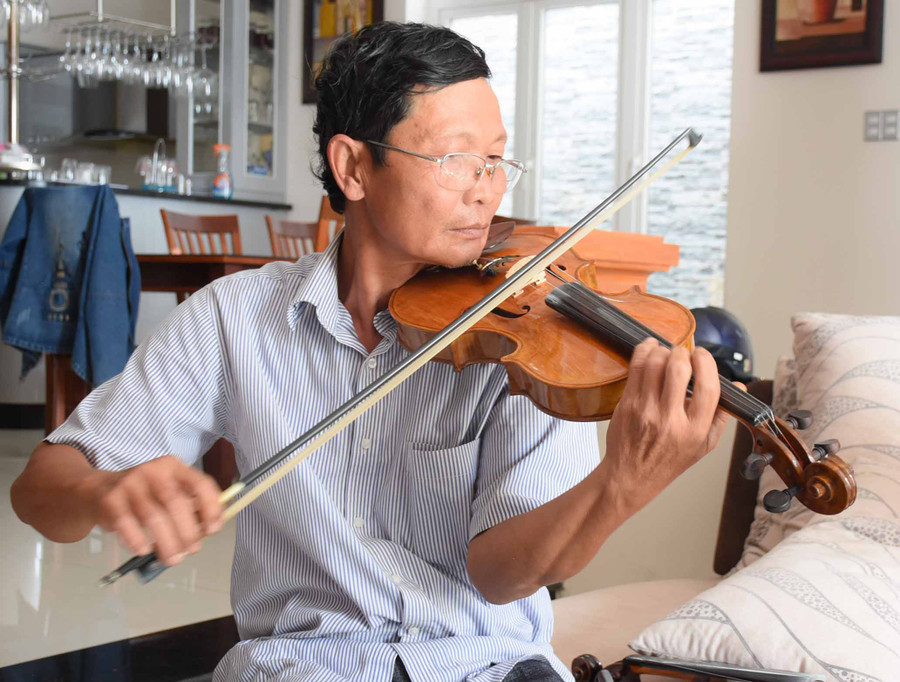 Ông Vũ Văn Tam Lang say sưa biểu diễn cùng chiếc đàn violon do chính ông chế tác. Ảnh: Phương Duyên