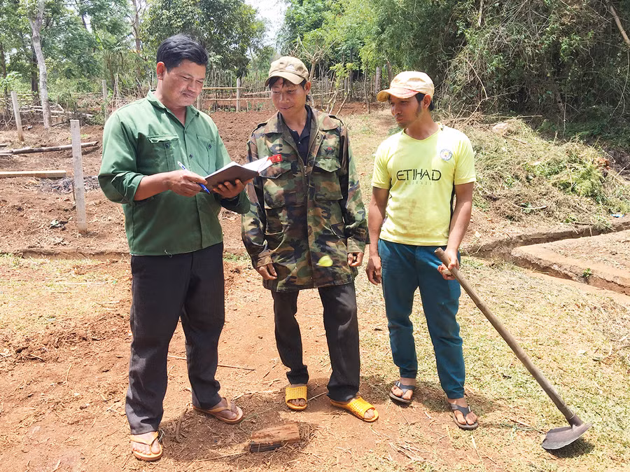 Ông Nưn (bìa trái) vận động bà con nạo vét kênh mương nội đồng, khơi thông dòng chảy. Ảnh: R'Ô Hok