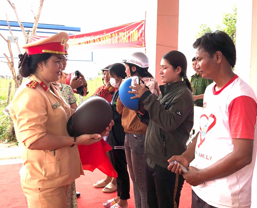 Thượng tá Lương Thị Thu Quỳnh-Trưởng phòng PC08 (Công an tỉnh) tặng mũ bảo hiểm cho người dân xã Ia Ke (huyện Phú Thiện). Ảnh Lê Hòa 