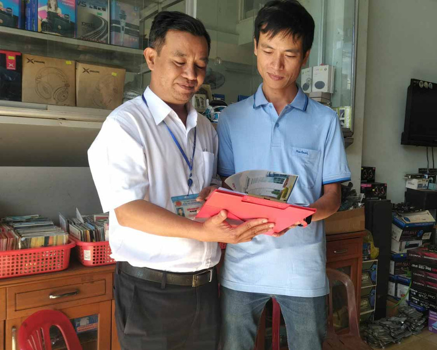 Cán bộ Chi cục Thuế Pleiku hướng dẫn hộ kinh doanh kê khai thuế. Ảnh: Sơn Ca