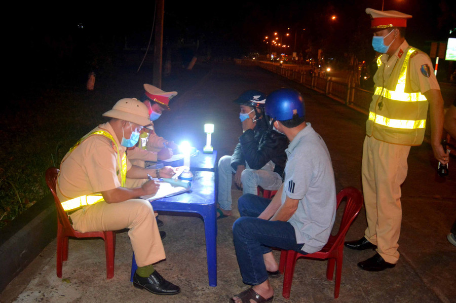 Tổ công tác Phòng Cảnh sát Giao thông (Công an tỉnh) lập biên bản xử phạt hành chính các trường hợp vi phạm. Ảnh: Hữu Trường