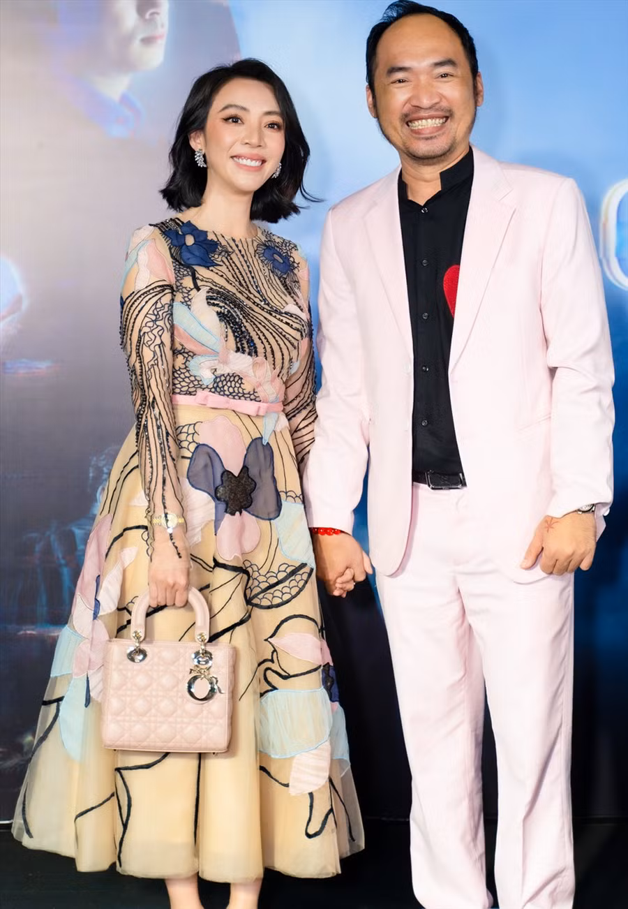 Thu Trang và Tiến Luật diện đồ đôi, nắm tay tình cảm trong sự kiện. Ảnh: NSCC.