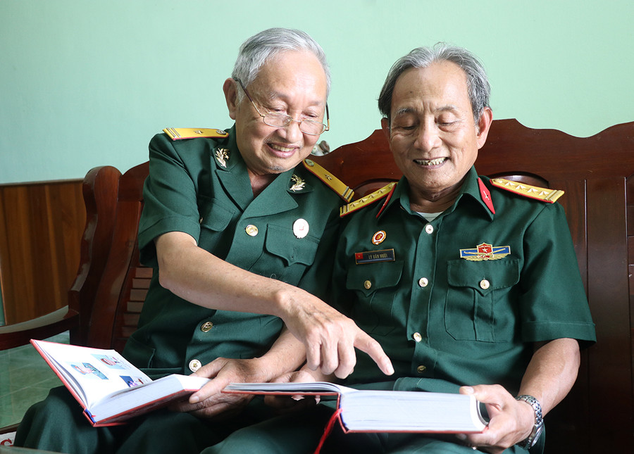 Ông Lê Minh Tân (bìa trái) cùng đồng đội đọc những trang sử hào hùng. Ảnh: Ngọc Minh Ông Lê Minh Tân (bìa trái) cùng đồng đội đọc những trang sử hào hùng. Ảnh: Ngọc Minh