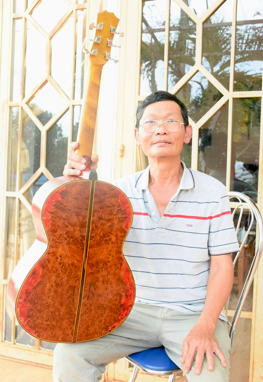 Ông Tam Lang bên chiếc đàn guitar đầu tiên chế tác bằng gỗ nu hương và pơ mu