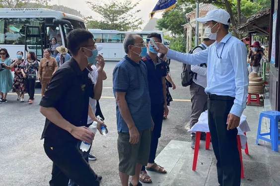 Đo thân nhiệt du khách tại khu di tích danh thắng Ngũ Hành Sơn, TP Đà Nẵng .Ảnh: BÍCH VÂN