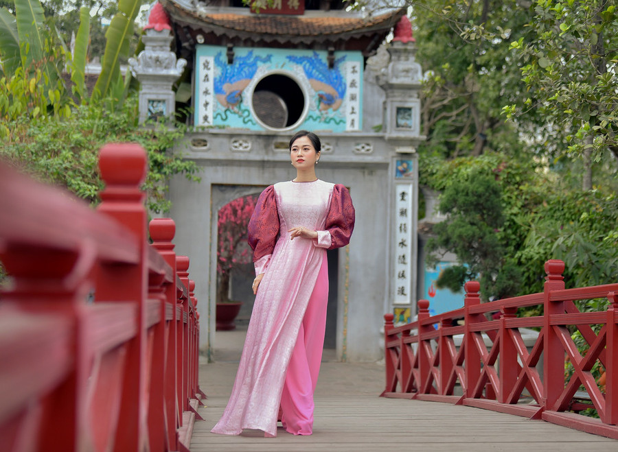 Thay vì tay áo dài truyền thống, NTK Đức Hùng đã biến tấu thành những chi tiết tay đèn lồng, tay cánh tiên phồng to, gấu tay gấp nếp bồng bềnh.